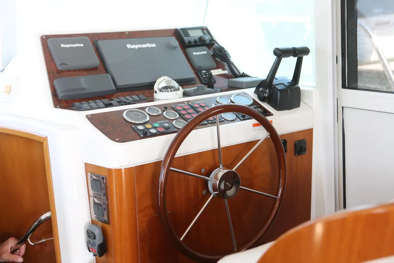 Gracie May Yacht Photos Pics 2007 Beneteau Swift Trawler 42 helm with wooden steering wheel and navigation instruments.