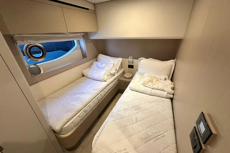  Yacht Photos Pics Interior of 2022 Azimut 68 yacht cabin with twin beds and porthole window.