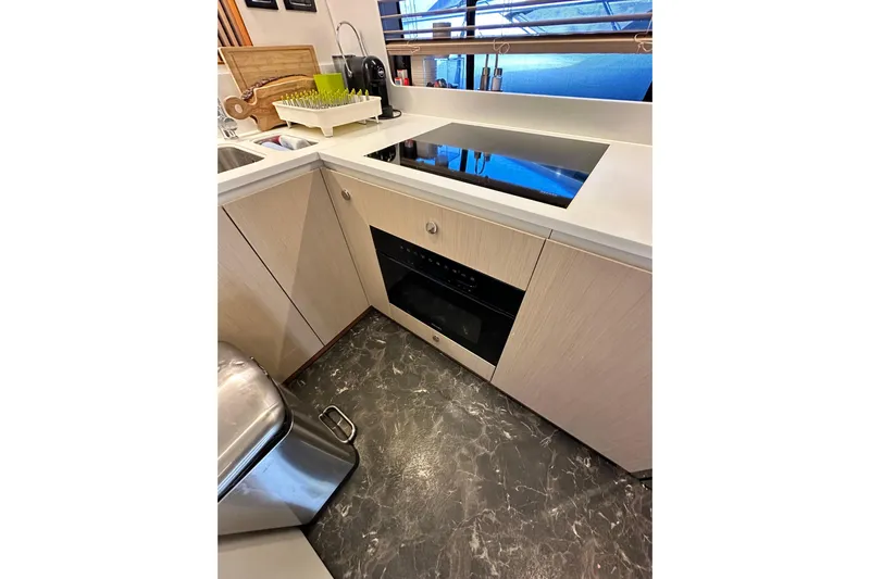  Yacht Photos Pics Modern kitchen interior of 2022 Azimut 68 yacht with sleek appliances and marble flooring.