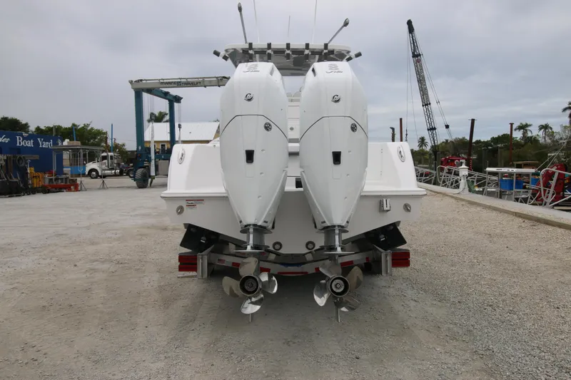  Yacht Photos Pics 2025 Invincible 33 Open Fisherman boat with dual outboard engines at a dockyard.