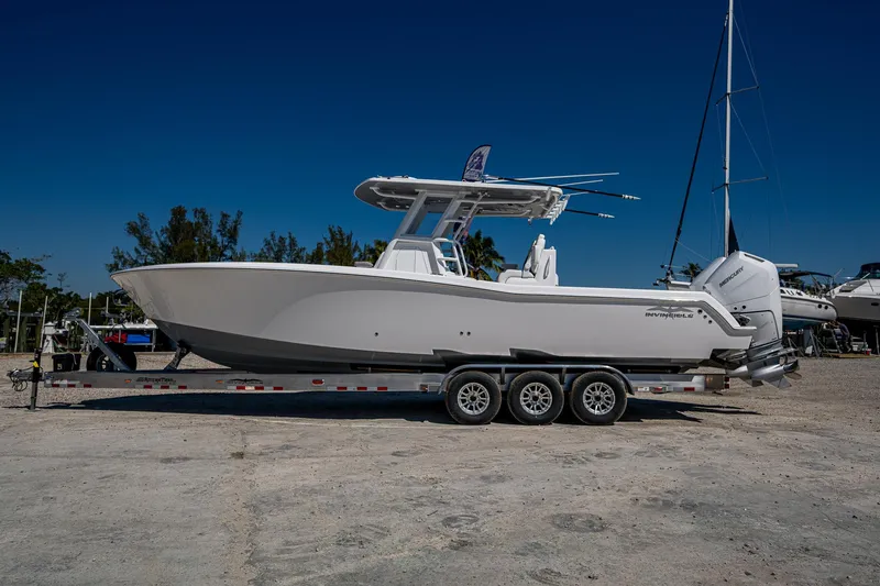 Yacht Photos Pics 2025 Invincible 33 Open Fisherman boat on trailer, side view, clear sky background.