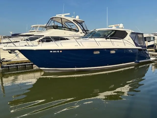  Yacht Photos Pics 2009 Tiara Yachts 4300 Sovran docked in a marina, reflecting on calm water.