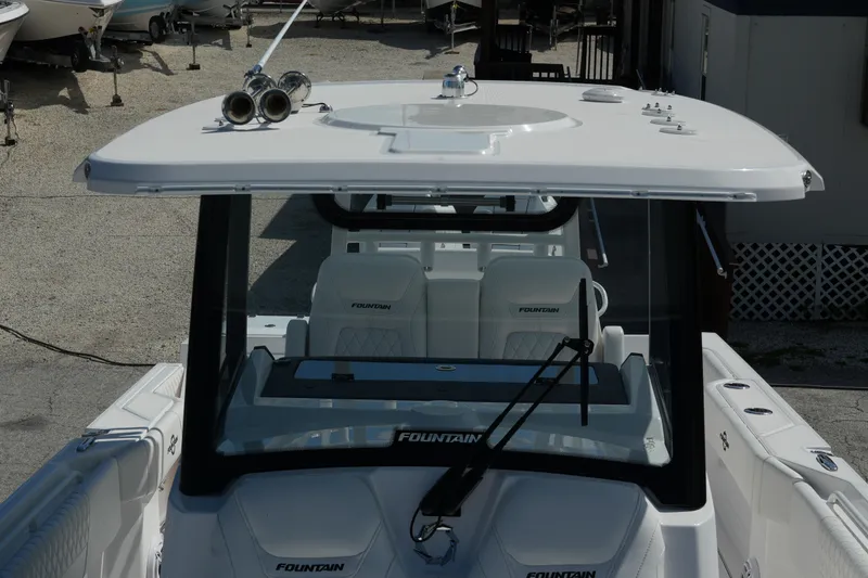  Yacht Photos Pics 2025 Fountain 32 NX boat with sleek design and modern features, docked outdoors.