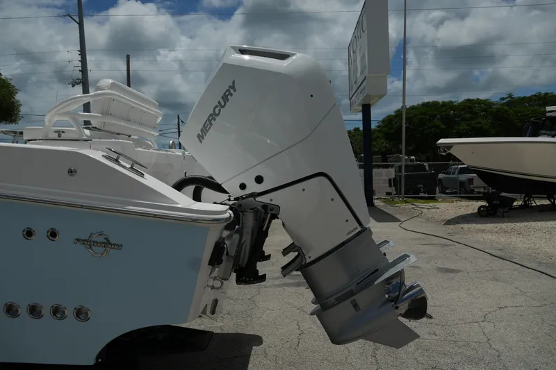  Yacht Photos Pics 2025 Fountain 32 NX boat with Mercury outboard motor, parked outdoors under cloudy sky.
