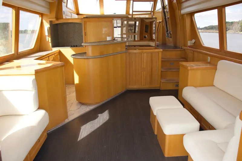  Yacht Photos Pics Luxurious interior of 2002 McKinna 57 Pilothouse yacht with elegant wood finishes and seating.