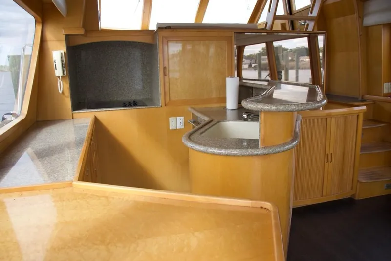  Yacht Photos Pics Luxurious 2002 McKinna 57 Pilothouse yacht interior with modern kitchen and wood finishes.