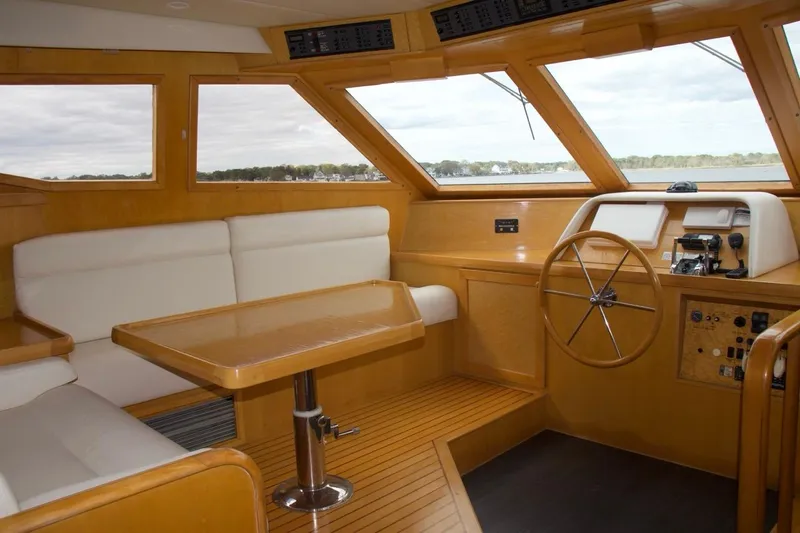  Yacht Photos Pics Luxurious 2002 McKinna 57 Pilothouse interior with helm, wooden accents, and comfortable seating.