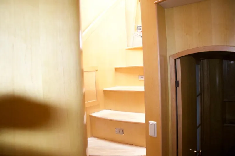  Yacht Photos Pics Interior staircase of 2002 McKinna 57 Pilothouse yacht, featuring wooden steps and walls.