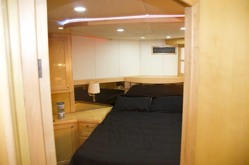  Yacht Photos Pics Luxurious bedroom interior of 2002 McKinna 57 Pilothouse yacht with wood accents and black bedding.