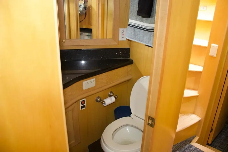  Yacht Photos Pics Bathroom interior of 2002 McKinna 57 Pilothouse yacht with wooden cabinetry and black countertop.