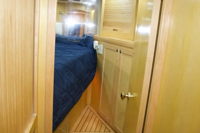  Yacht Photos Pics 2002 McKinna 57 Pilothouse cabin interior with wooden paneling and blue bedding.