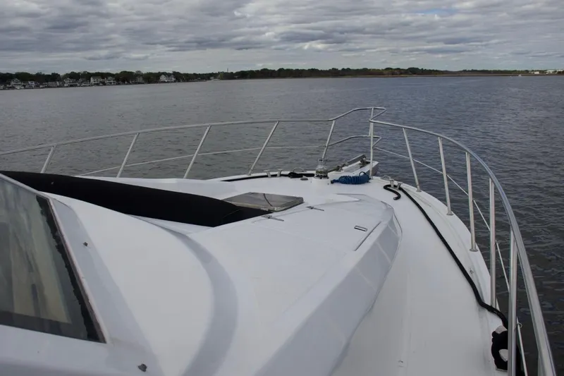  Yacht Photos Pics 2002 McKinna 57 Pilothouse yacht on calm waters under cloudy skies.