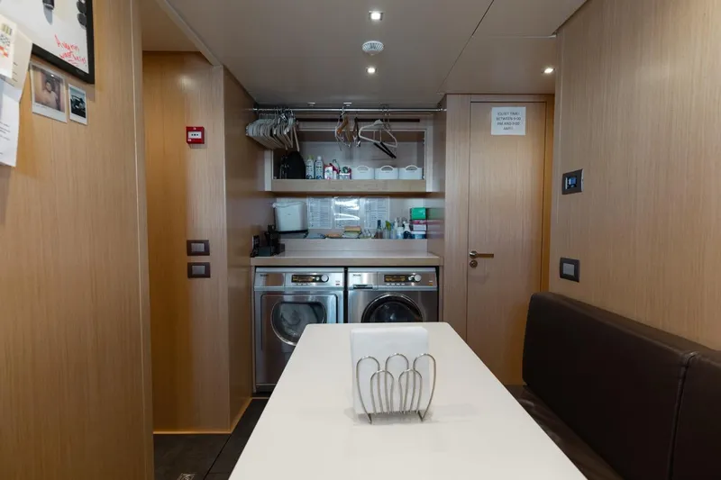 Fifty Shades Yacht Photos Pics Laundry area inside 2018 Sanlorenzo SL106 yacht with modern appliances and wooden interior.