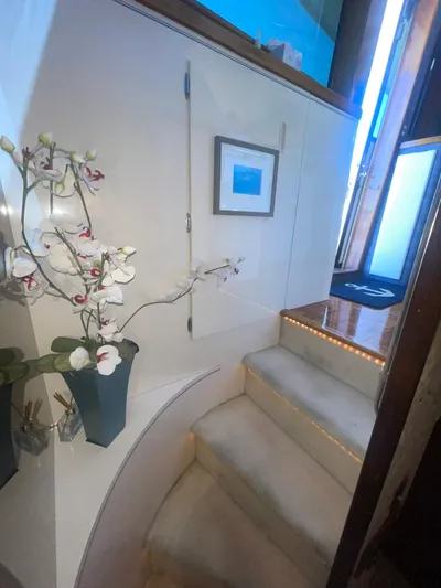 Gentle Ben Yacht Photos Pics Interior staircase of 1989 Hatteras 80 Cockpit Motor Yacht with elegant decor and lighting.