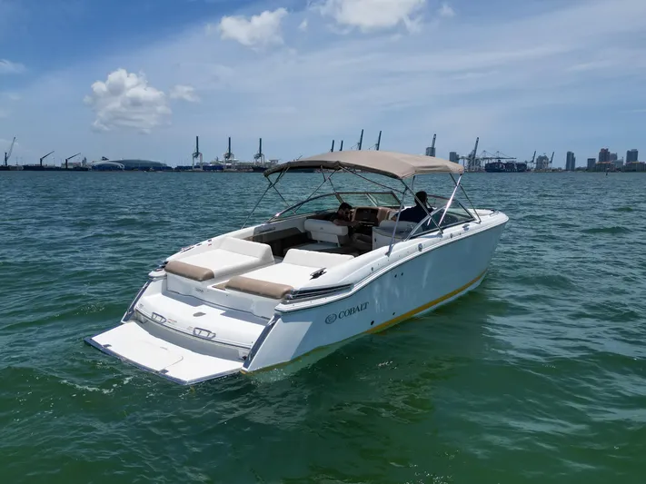  Yacht Photos Pics 2013 Cobalt 296 boat on water, city skyline in background, sunny day.