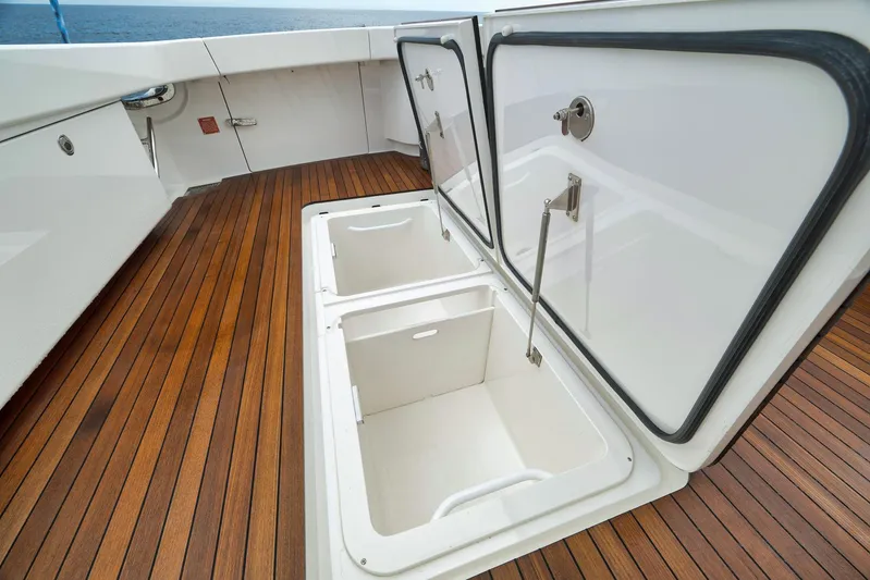Makara Yacht Photos Pics Open storage compartments on 2018 Viking 72 Sky Bridge yacht with wooden deck.