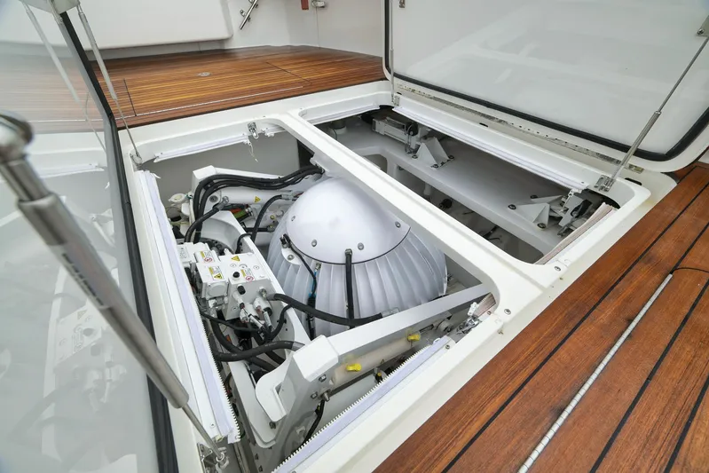 Makara Yacht Photos Pics Engine compartment of 2018 Viking 72 Sky Bridge yacht, showcasing mechanical components and wooden deck.