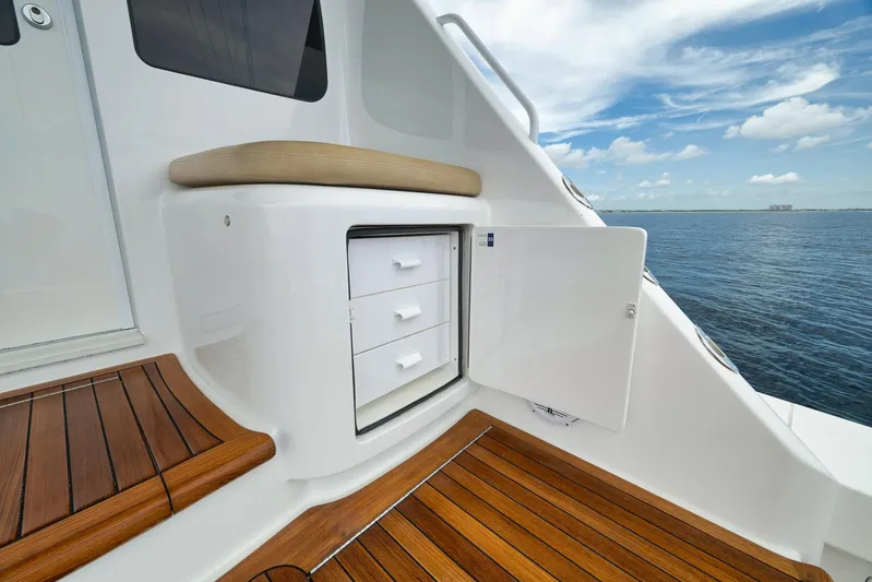 Makara Yacht Photos Pics 2018 Viking 72 Sky Bridge yacht with open storage, wooden deck, and ocean view.