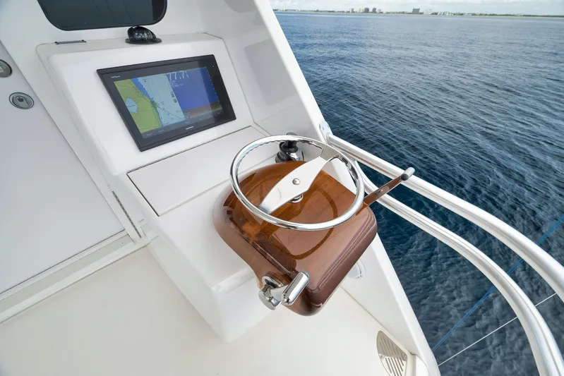 Makara Yacht Photos Pics Steering wheel and navigation screen on 2018 Viking 72 Sky Bridge yacht, overlooking ocean.