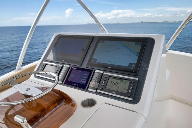 Makara Yacht Photos Pics Helm of 2018 Viking 72 Sky Bridge yacht with navigation screens and steering wheel.