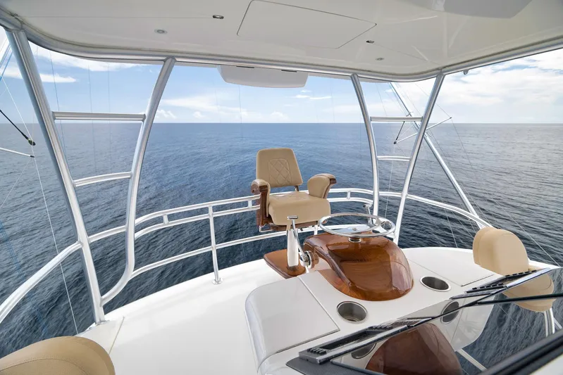 Makara Yacht Photos Pics 2018 Viking 72 Sky Bridge yacht helm with ocean view, featuring luxurious seating and controls.