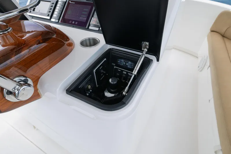 Makara Yacht Photos Pics 2018 Viking 72 Sky Bridge helm with open control panel and wooden steering wheel.