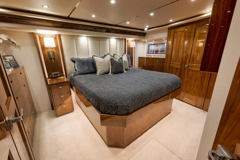 Makara Yacht Photos Pics Luxurious bedroom interior of 2018 Viking 72 Sky Bridge yacht with elegant wood finishes.