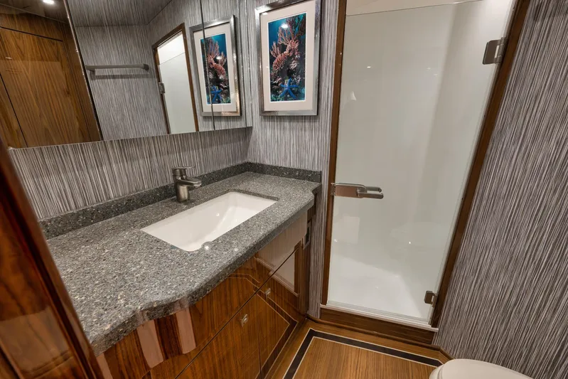 Makara Yacht Photos Pics Luxurious bathroom in 2018 Viking 72 Sky Bridge yacht with modern fixtures and elegant decor.