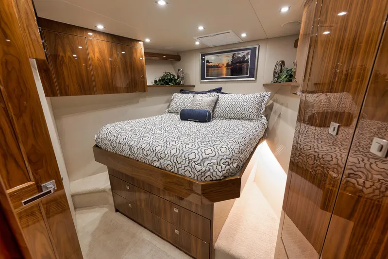 Makara Yacht Photos Pics Luxurious bedroom interior of 2018 Viking 72 Sky Bridge yacht with elegant wood finishes.