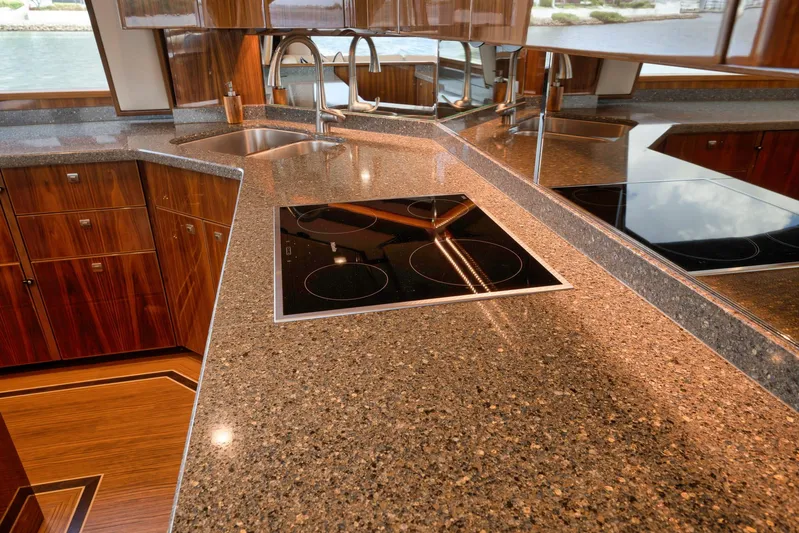 Makara Yacht Photos Pics Luxurious kitchen interior of 2018 Viking 72 Sky Bridge yacht with sleek countertops and modern appliances.