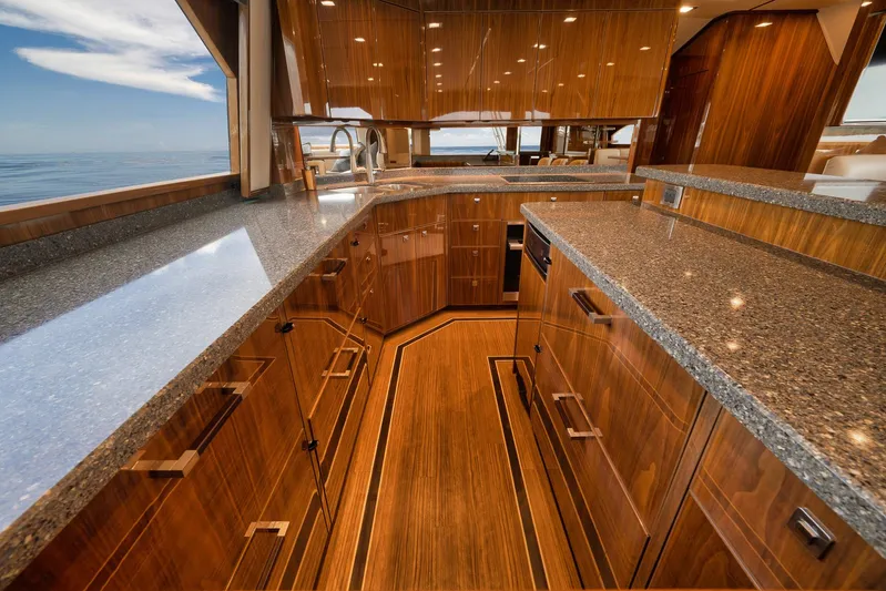 Makara Yacht Photos Pics Luxurious kitchen interior of 2018 Viking 72 Sky Bridge yacht with sleek wood cabinetry.