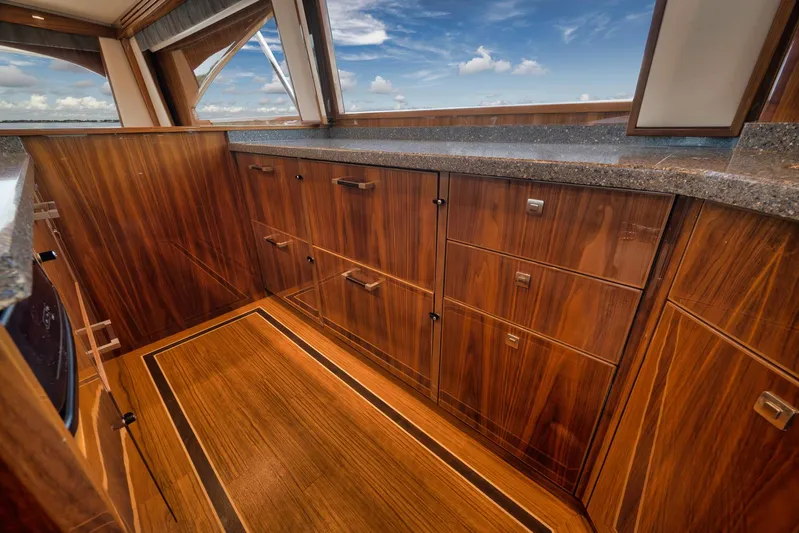 Makara Yacht Photos Pics Luxurious wood cabinetry in 2018 Viking 72 Sky Bridge yacht interior, featuring sleek countertops.