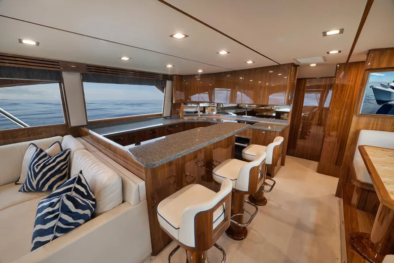 Makara Yacht Photos Pics Luxurious interior of 2018 Viking 72 Sky Bridge yacht with elegant seating and modern kitchen.