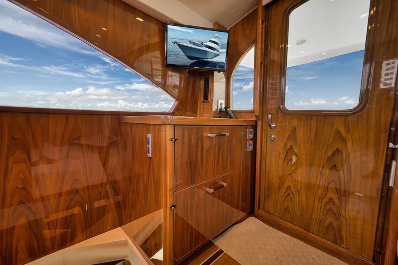 Makara Yacht Photos Pics Luxurious interior of 2018 Viking 72 Sky Bridge yacht with polished wood finish.