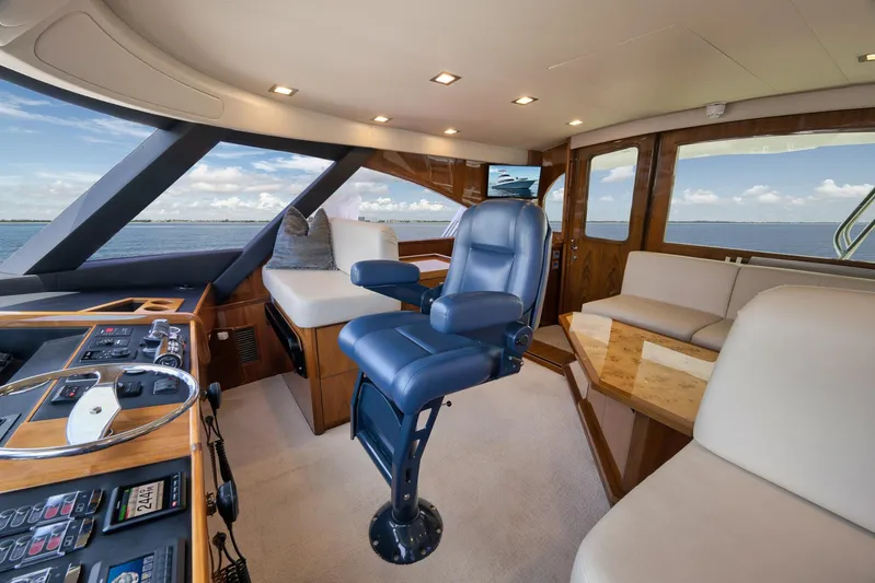 Makara Yacht Photos Pics Luxurious interior of 2018 Viking 72 Sky Bridge yacht with captain's chair and panoramic windows.