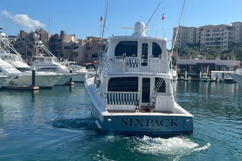 Sixpack Yacht Photos Pics 2013 Hatteras GT63 yacht "Sixpack" docked in a marina, clear blue water.