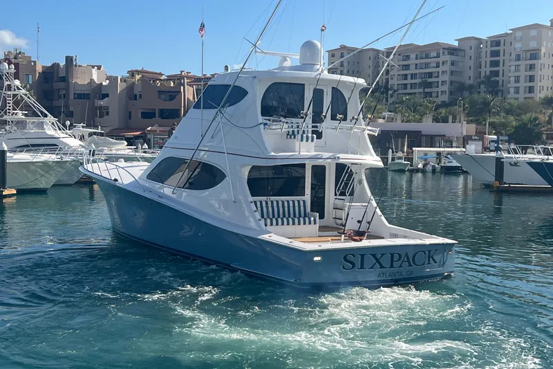 Sixpack Yacht Photos Pics 2013 Hatteras GT63 yacht "Six Pack" in marina, surrounded by buildings and boats.