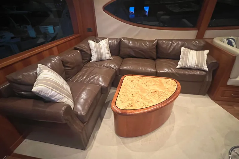 Sixpack Yacht Photos Pics Luxurious leather seating area on 2013 Hatteras GT63 yacht with stylish wooden table.