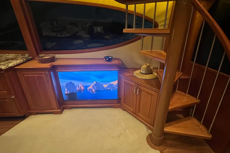 Sixpack Yacht Photos Pics Luxurious interior of 2013 Hatteras GT63 yacht with wooden spiral staircase and flat-screen TV.