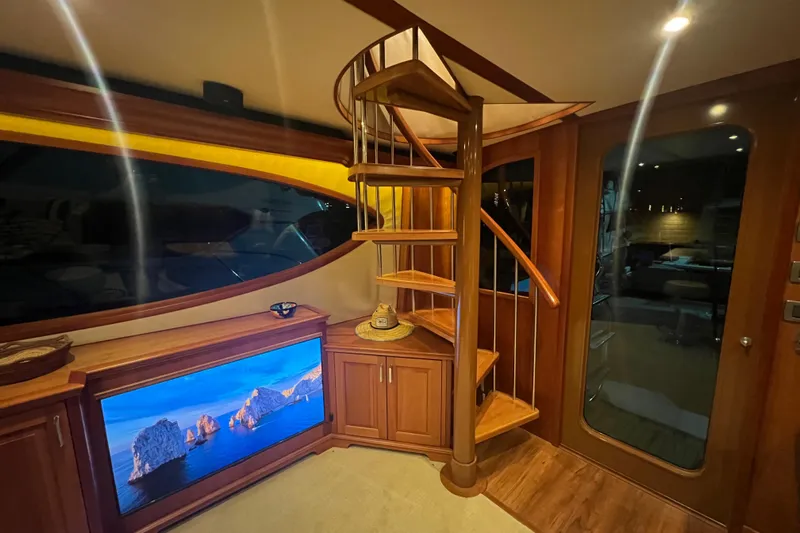 Sixpack Yacht Photos Pics Luxurious 2013 Hatteras GT63 yacht interior with spiral staircase and scenic TV display.
