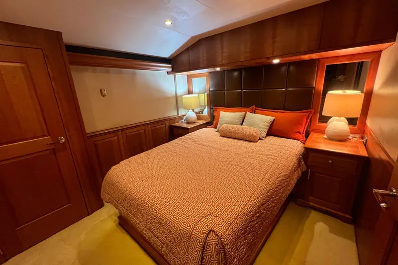 Sixpack Yacht Photos Pics Luxurious bedroom interior of 2013 Hatteras GT63 yacht with elegant wood finishes and cozy lighting.