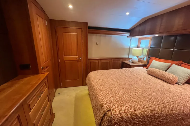 Sixpack Yacht Photos Pics Luxurious 2013 Hatteras GT63 yacht bedroom with wood paneling and cozy bedding.
