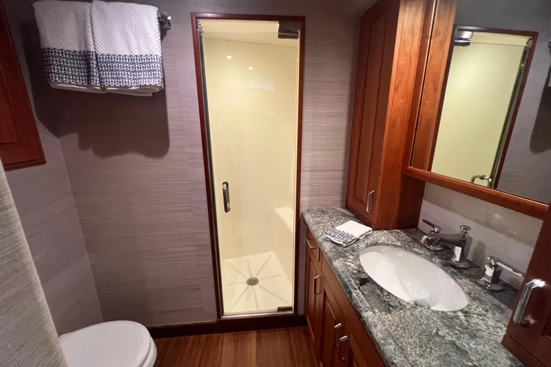 Sixpack Yacht Photos Pics Luxurious bathroom in 2013 Hatteras GT63 yacht with granite countertop and glass shower.