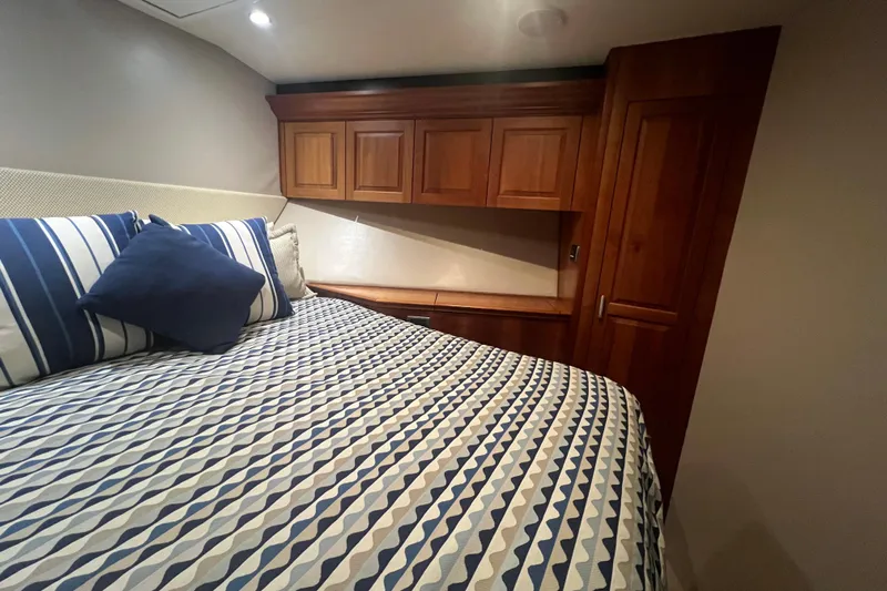 Sixpack Yacht Photos Pics Luxurious cabin interior of 2013 Hatteras GT63 yacht with patterned bedding and wooden cabinetry.
