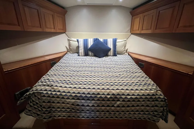 Sixpack Yacht Photos Pics Luxurious cabin interior of 2013 Hatteras GT63 yacht with patterned bedding and wooden cabinets.