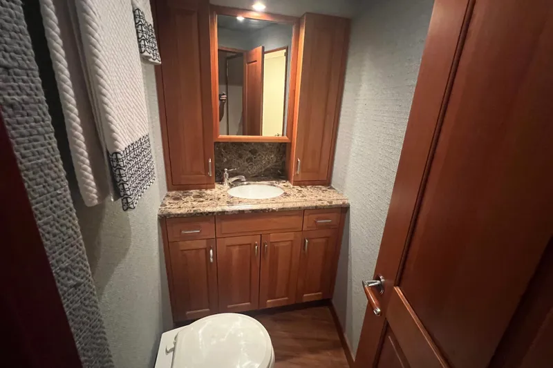 Sixpack Yacht Photos Pics Luxurious bathroom in 2013 Hatteras GT63 yacht with wooden cabinetry and granite countertop.