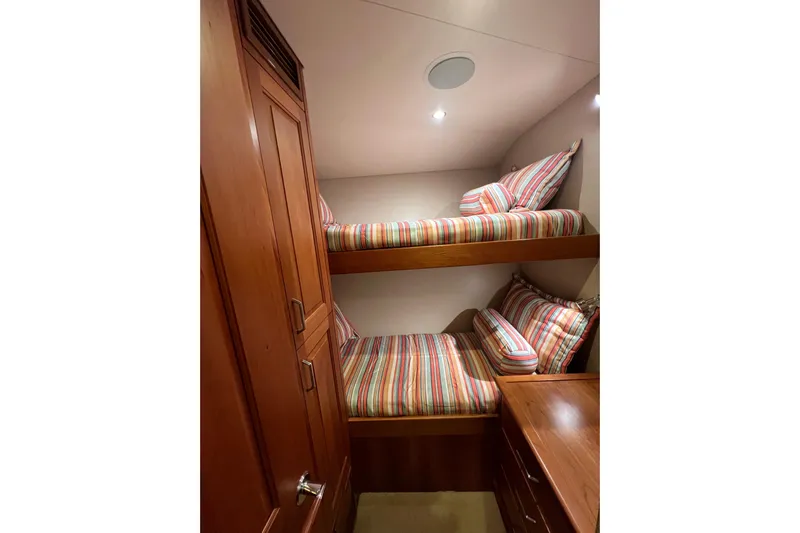 Sixpack Yacht Photos Pics 2013 Hatteras GT63 yacht cabin with striped bunk beds and wooden cabinetry.