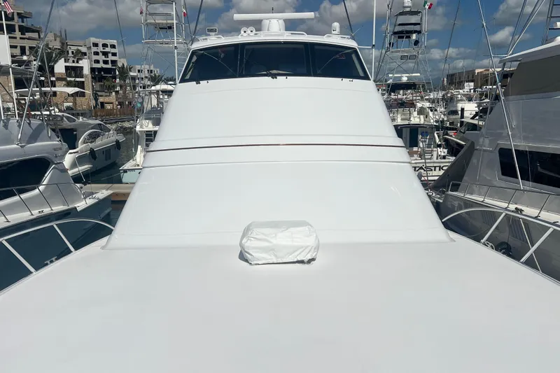 Sixpack Yacht Photos Pics 2013 Hatteras GT63 yacht docked in a marina, surrounded by other boats.