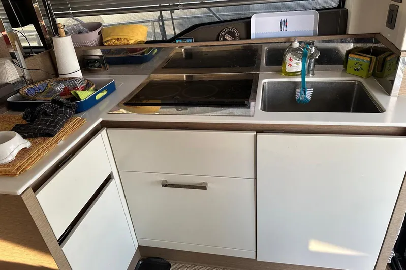 Lola Yacht Photos Pics Compact kitchen area in a 2019 Prestige 460 yacht with sink and stovetop.