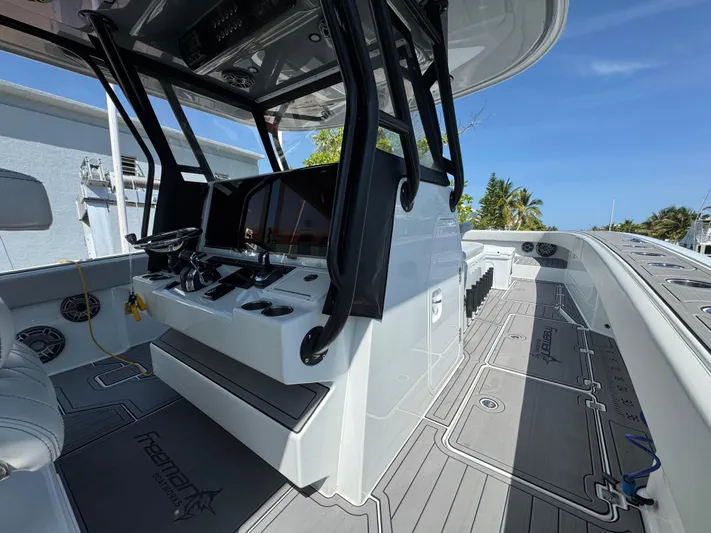  Yacht Photos Pics Sleek 2021 Freeman 47 boat interior with modern controls and spacious deck under clear blue sky.